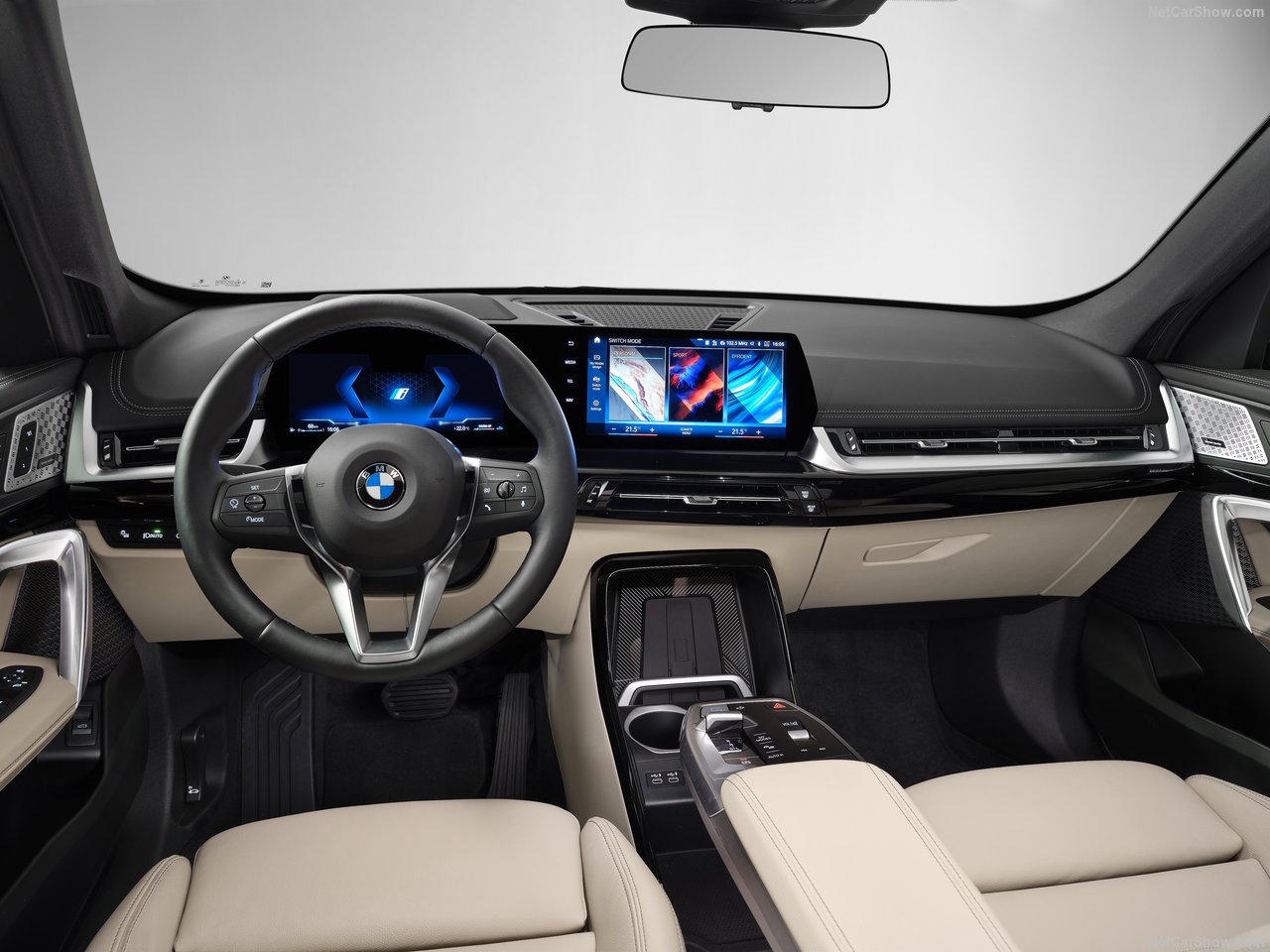 Wnętrze BMW X1 z nowoczesnym kokpitem i ekranami dotykowymi.