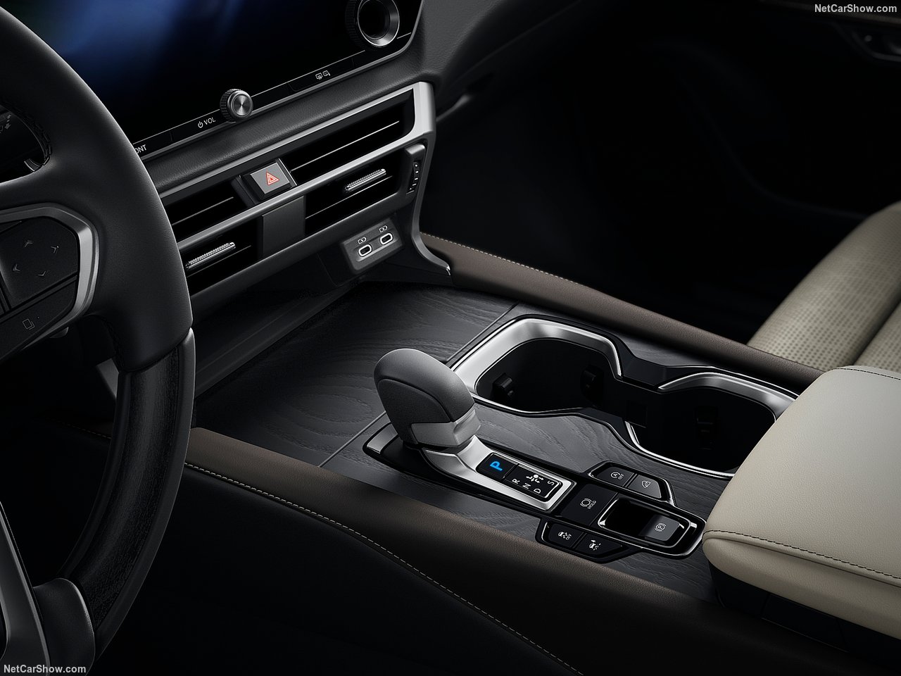 Wnętrze Lexus RX 350h Prestige, widok na konsolę środkową z dźwignią zmiany biegów i uchwytami na napoje.