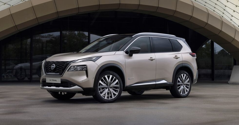 Nissan X-Trail Tekna 1.5 e-POWER e-4ORCE, 7-miejscowy SUV na tle nowoczesnej architektury.
