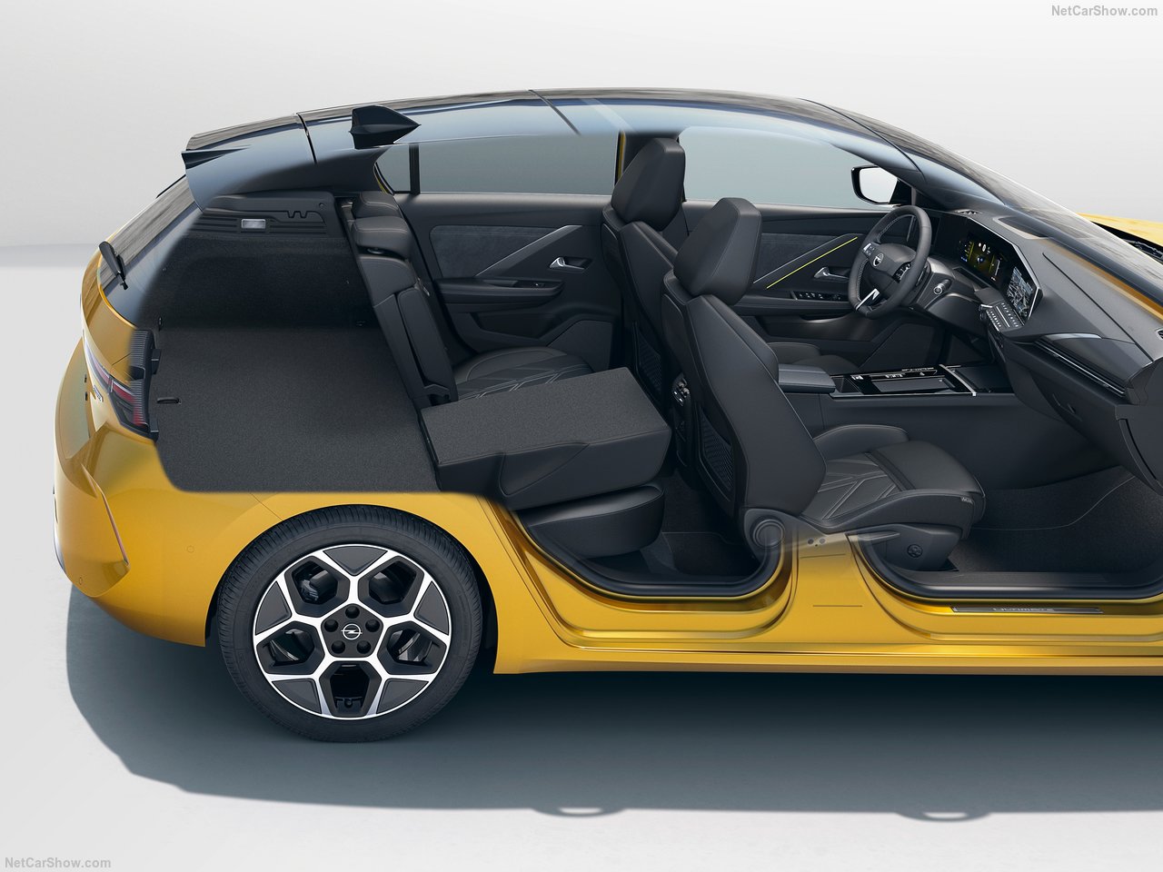 Wnętrze i bagażnik żółtego Opel Astra 1.2 Turbo GS z otwartymi drzwiami uchylonymi siedzeniami.