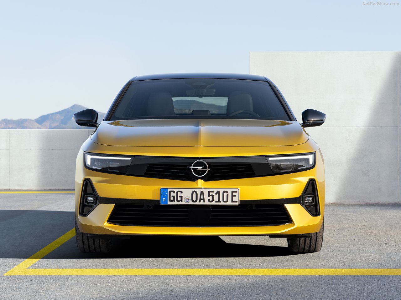 Żółty Opel Astra 1.2 Turbo GS widziany z przodu na tle górskiego krajobrazu.