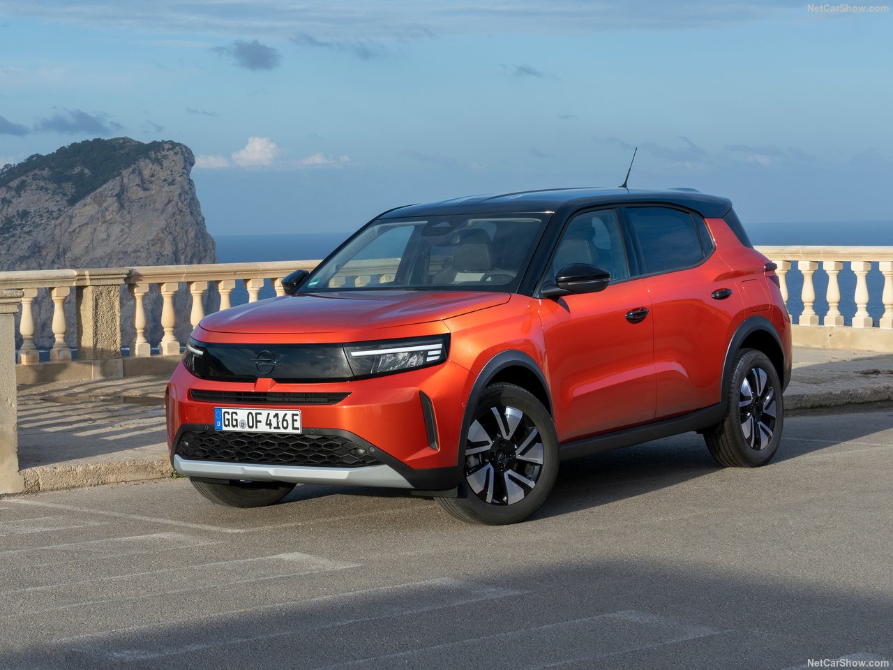 Opel Frontera GS 1.2 Turbo Hybrid w kolorze pomarańczowym na tle nadmorskiego klifu.