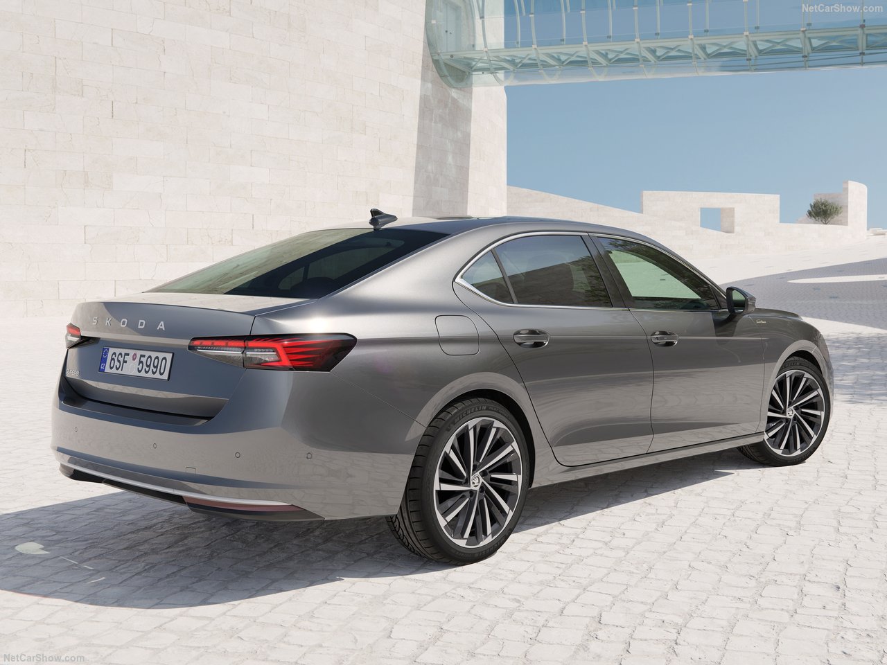 Škoda Superb 2.0 TSI Selection, szary sedan, widok z tyłu, na tle nowoczesnej architektury.